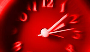 Red clock with speedy blurred effect. Concept of fast time passing.