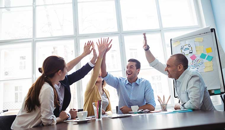 Five people in meeting giving high fives