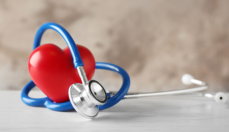 Stethoscope and red heart on table