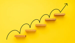 Rising arrow on staircase on yellow background - improvement concept