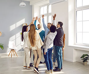 Team high fiving in office