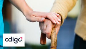 Young persons hand on older persons hand with cane