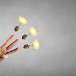 Three fingers pointing at three lightbulbs - information and ideas concept