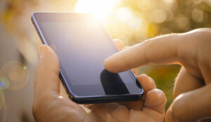 Close up of a person using mobile smart phone outdoors