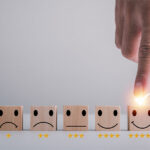 Customer rating with hand choosing five star smiley face