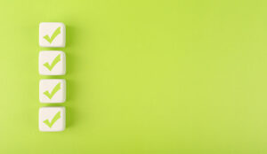 Four checkmarks on white cubes against bright green background