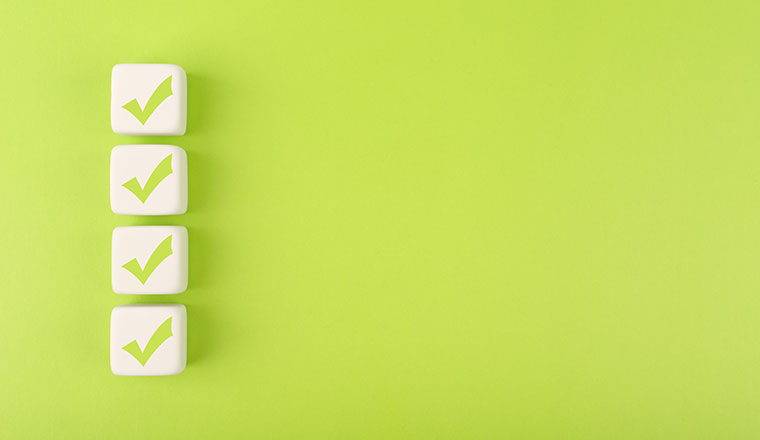 Four checkmarks on white cubes against bright green background