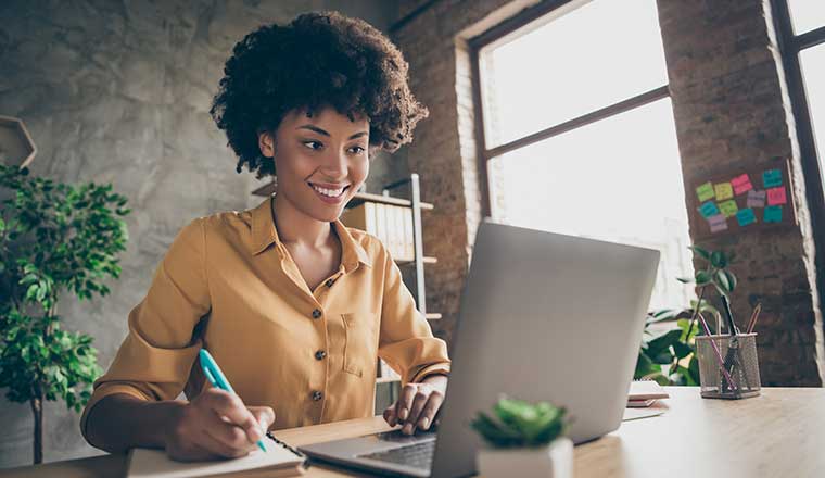 Person taking notes during virtual coaching session