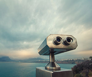 Scope concept with binoculars looking over skyline