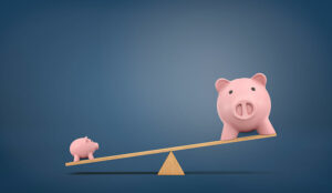 Financial comparison and the concept of balancing budgets with piggy banks on scale