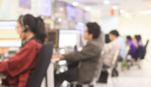 Blurred call centre scene with customer service agents