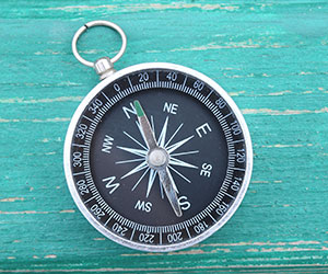 A compass on a blue wooden background