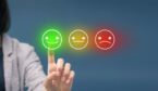 Person pressing happy smiley face emoticon on virtual touch screen - customer satisfaction rating