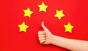 A hand showing thumb-up and five stars on red background