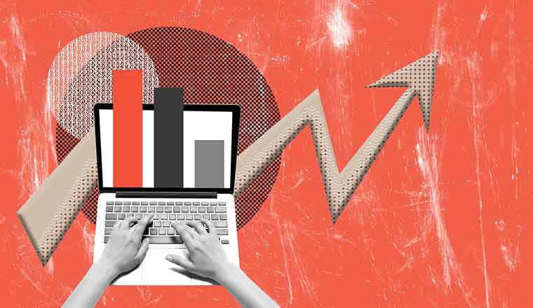 Human hands working on laptop with graphs and analytics.