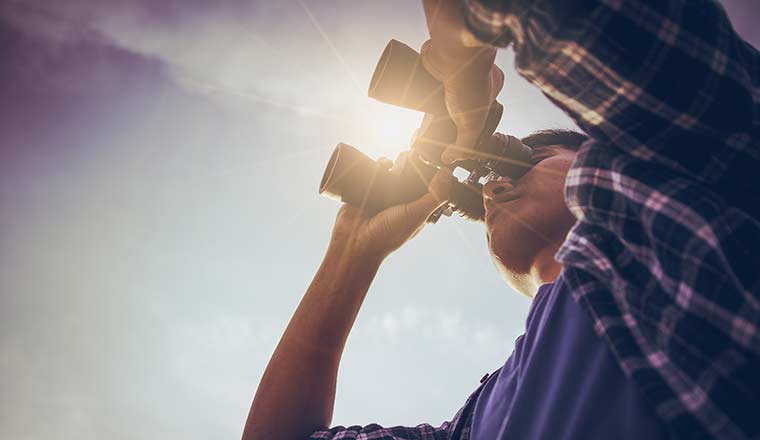 Looking to the future concept with person using binoculars