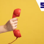 A hand holding and showing red telephone