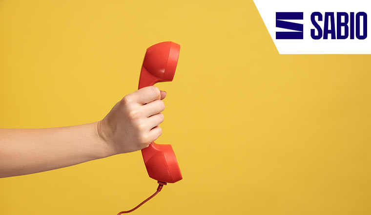 A hand holding and showing red telephone