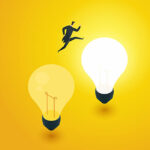 Development and transition idea with person jumping from one lightbulb to a lit one