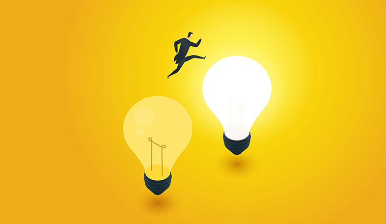 Development and transition idea with person jumping from one lightbulb to a lit one