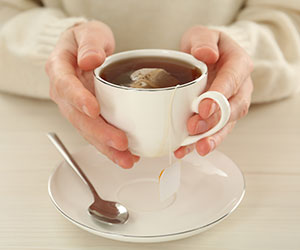 Person holding cup of tea