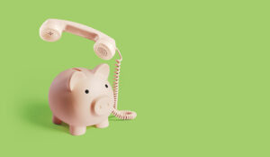 A piggy bank telephone on a green background