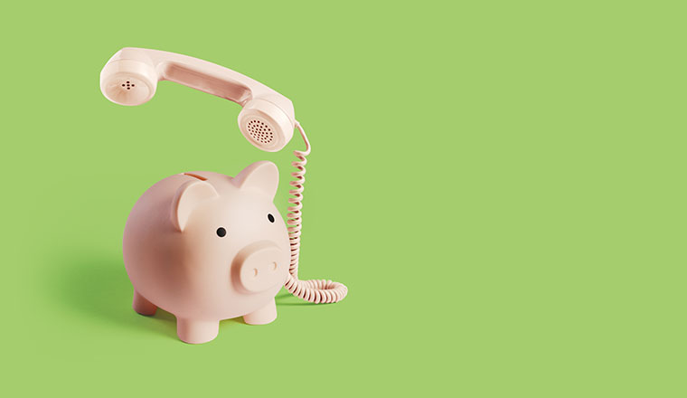 A piggy bank telephone on a green background