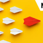Red paper plane leading others - leadership concept
