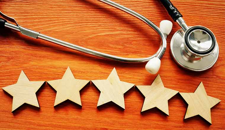 Patient experience and satisfaction concept. Stethoscope and five stars.