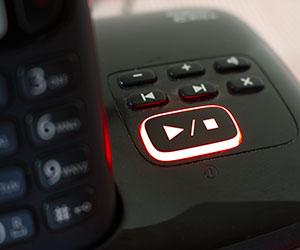 Simon J Beer - Shutterstock - 1037682907 Stop and play button on a landline answering machine