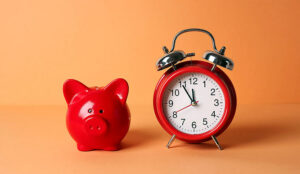 Red piggy bank and classic alarm clock - time banked concept