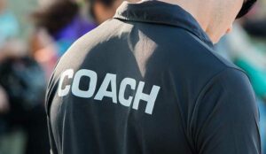 Coaching concept with a person in a black shirt that says coach