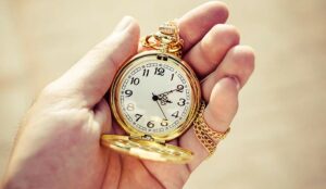 Golden pocket watch in hand close up.