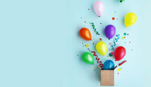 Celebration concept with balloons and confetti coming out of box