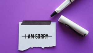 Pen crossed out 'I am Sorry' on note
