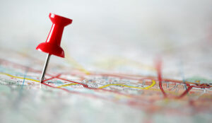 Red pushpin showing the location of a destination point on a map - customer journey map concept