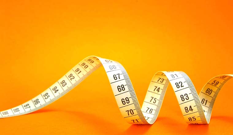 Measuring Tape On Orange Background