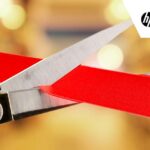Unveil concept with scissors cutting red ribbon