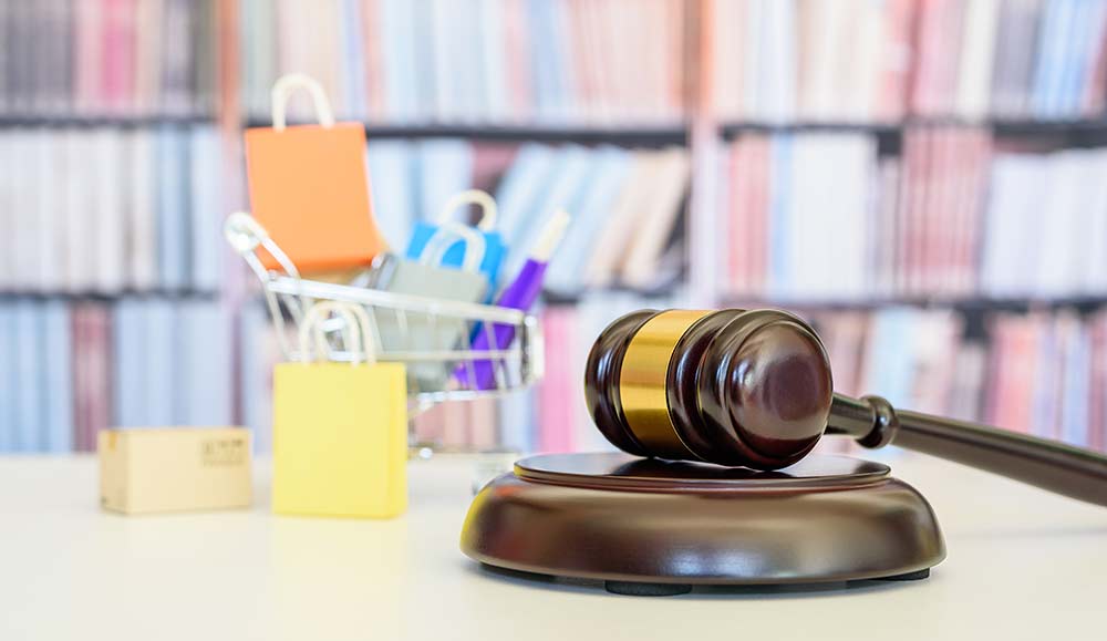 Judge gavel with mini shopping bags and cart in the background