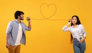 2 people holding cups with a love heart attached