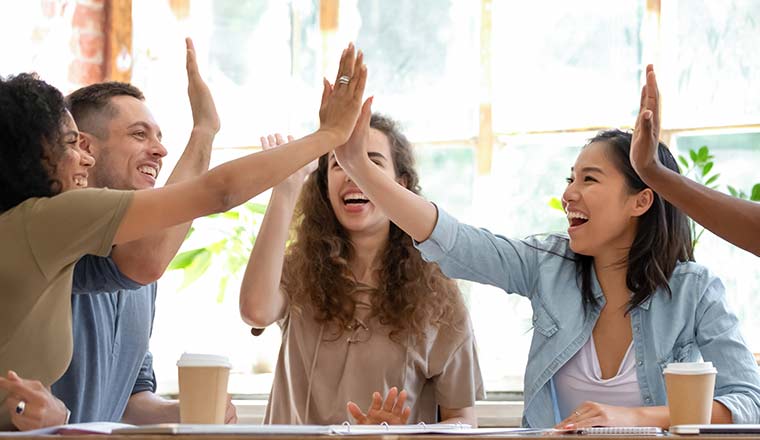 Happy engaged team giving a high five