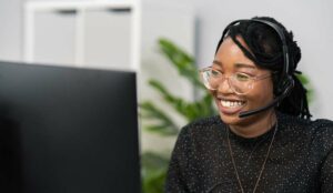 Happy call centre agents sat at a desk with a headset on