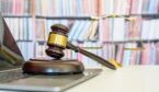 Judge gavel and base, with justice scale on laptop