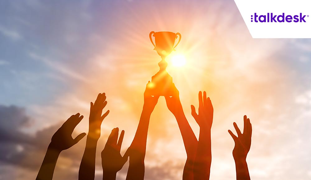 people with their hands in the air holding a trophy