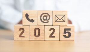 2025 in wood blocks with a call centre phone in a wooden block, an @ symbol and a email symbol