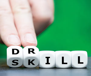 Hand turns dice and changes the word skill to drill.
