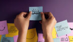 Happy customers putting post it notes on wall