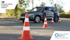 Examiner instructing student before exam at driving school test track, focus on traffic cone