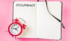 Notepad on a pink background with a clock