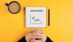 Hands of a businessman and a spiral notebook with the word 'shrinkage' written on it
